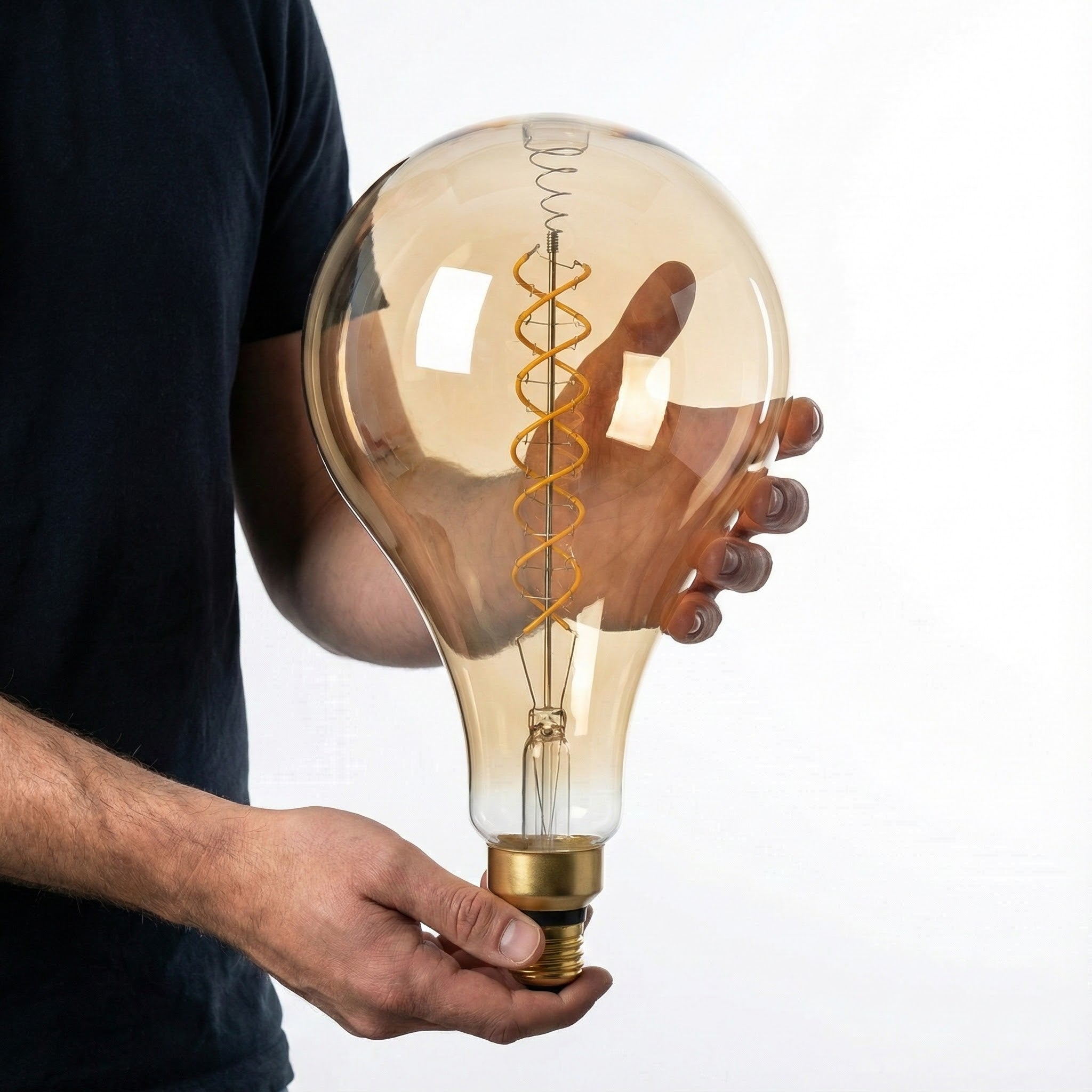 Person holding a large, vintage-style light bulb against a white background
